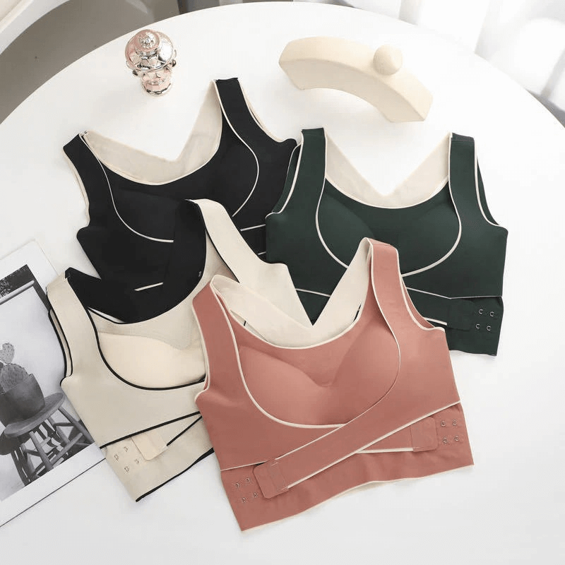 Stylish elastic cross back push up sports bras with front closure in various colors displayed on a table.